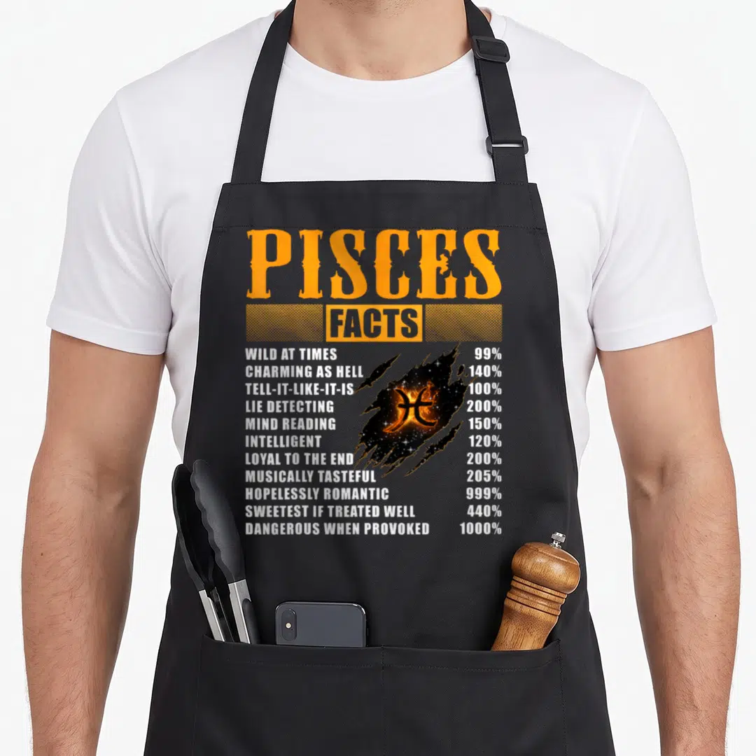 Pisce fact birthday apron - Orange and white Pisces facts list with nebula symbol on black apron — shown on a black cotton canvas apron against a white background