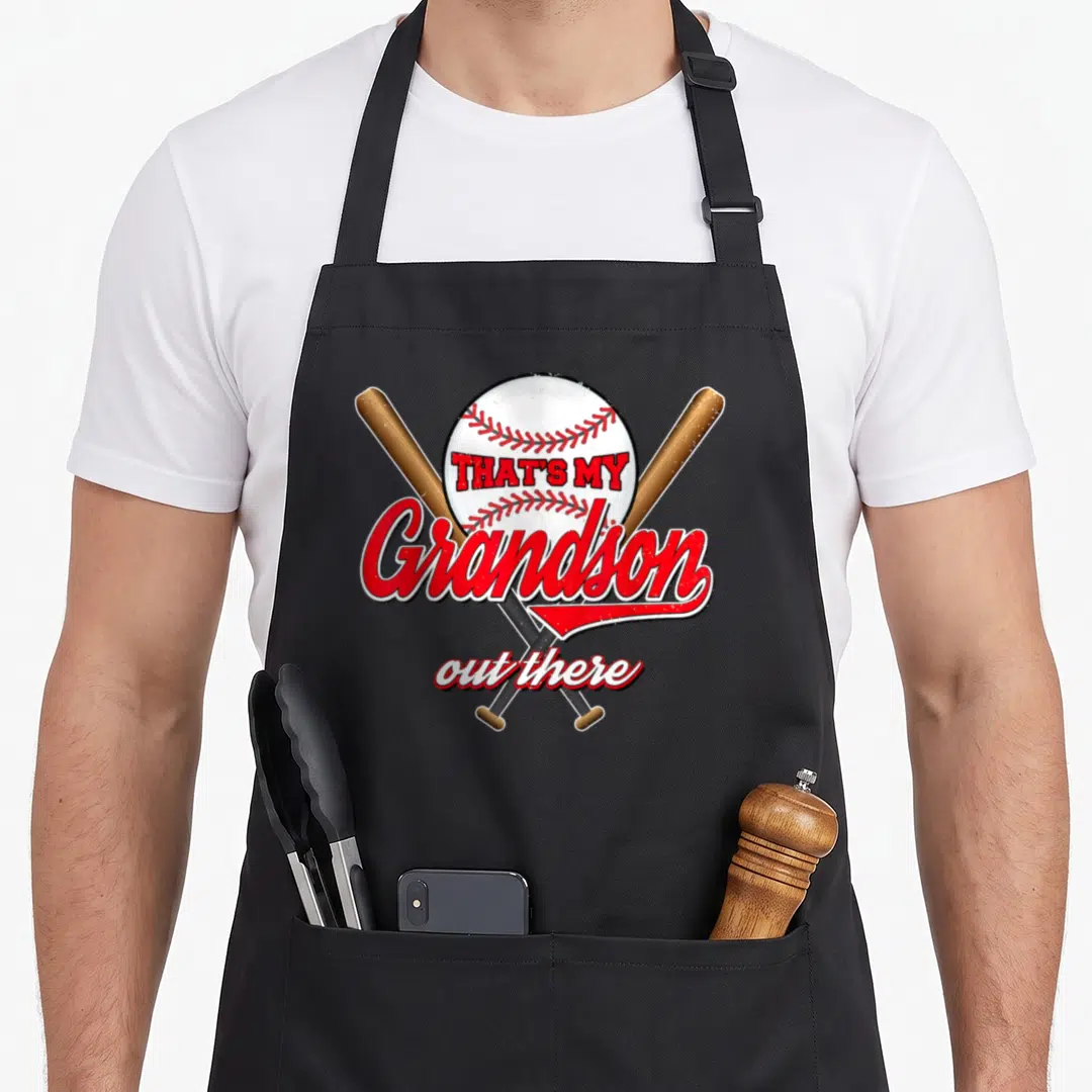 Granny grandma apron - Baseball and crossed bats with That's My Grandson Out There text in red script — shown on a black cotton canvas apron against a white background