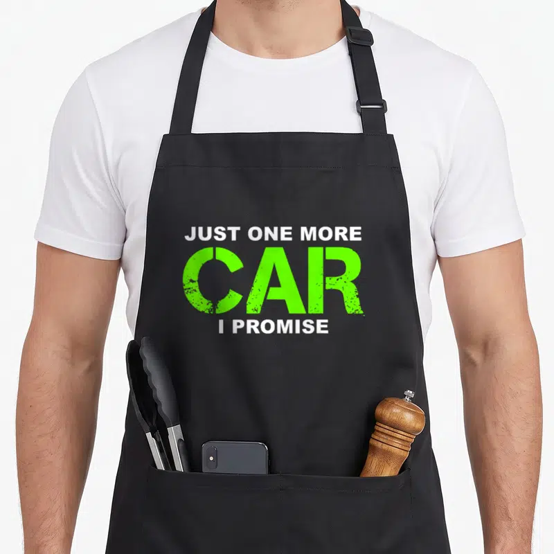 Promise enthusiast car apron - Distressed white and lime green text reading Just One More Car I Promise — shown on a black cotton canvas apron against a white background