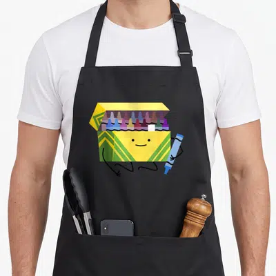 Crayon teacher apron - Smiling yellow crayon box with green stripes holding a blue crayon in cartoon style — shown on a black cotton canvas apron against a white background