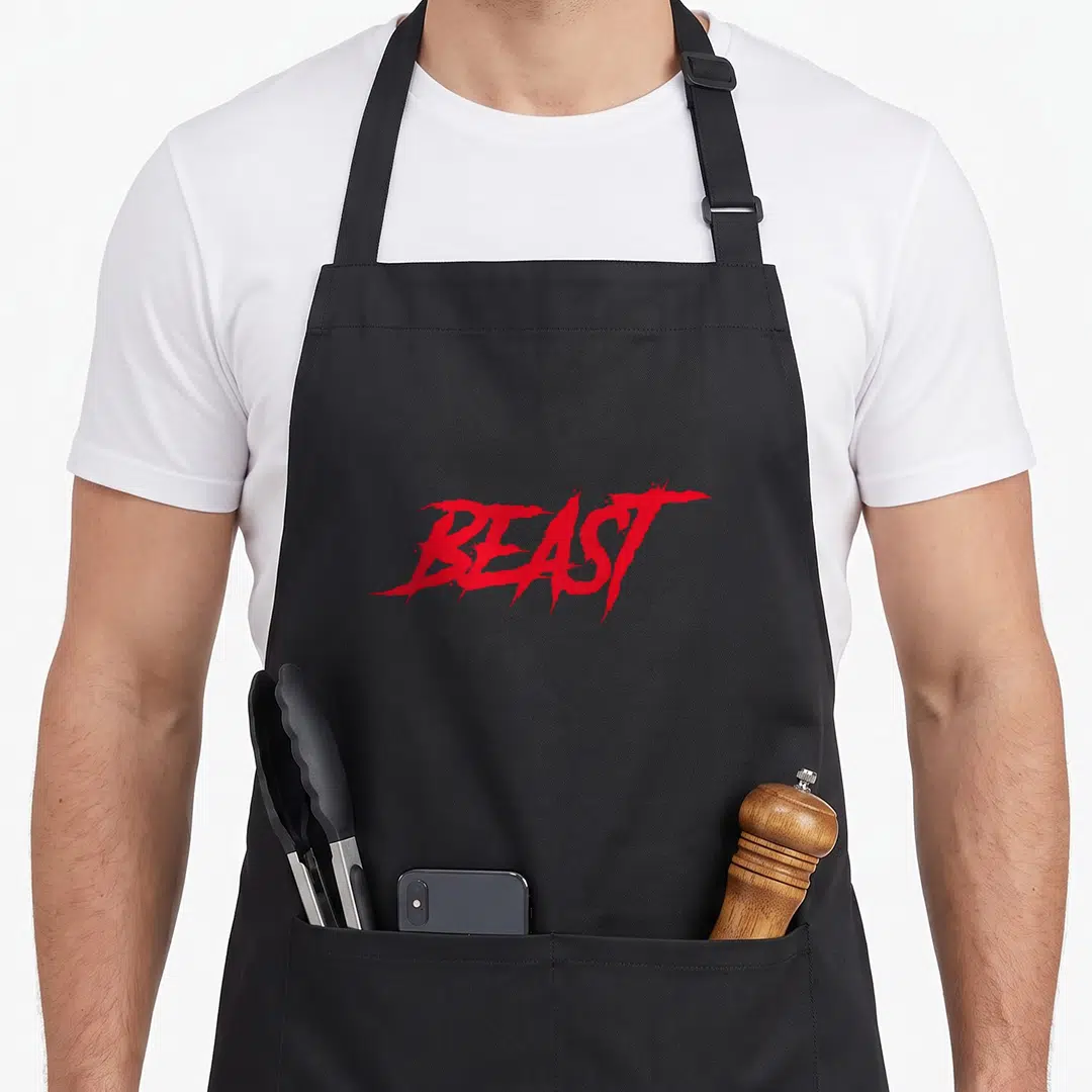 Gear beast mode apron - Red jagged text reading BEAST on grey background — shown on a black cotton canvas apron against a white background