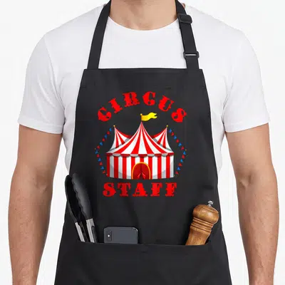 Staff birthday apron - Red and white striped circus tent with CIRCUS STAFF text and blue red bunting flags — shown on a black cotton canvas apron against a white background