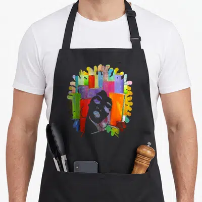 Strong trendy apron - Grey woman silhouette over multicolored abstract paint blocks in red, blue, yellow, green — shown on a black cotton canvas apron against a white background