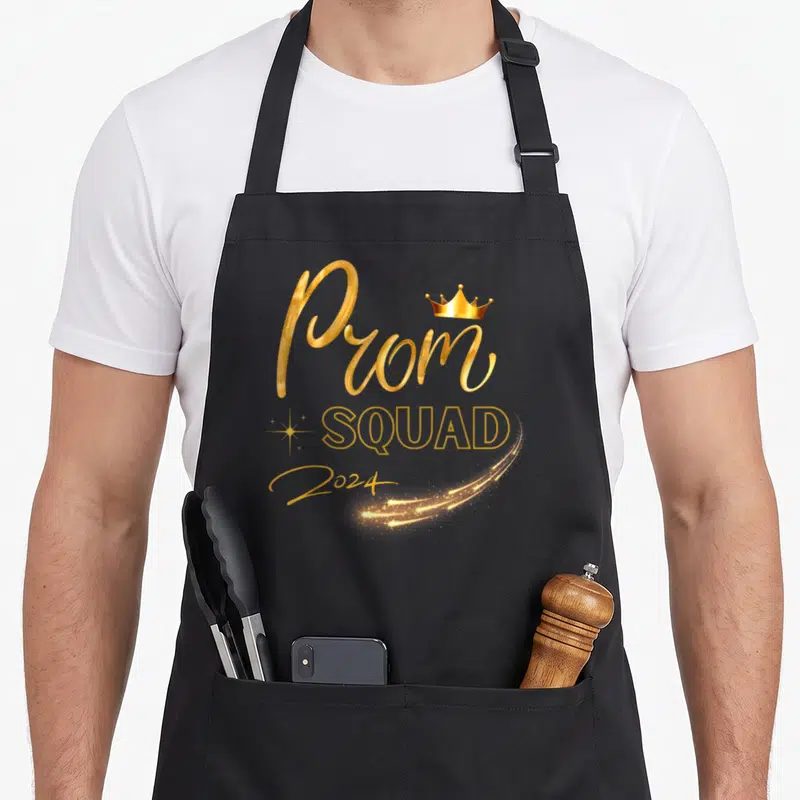 Class prom apron - Gold Prom SQUAD 2024 text with crown and sparkles on black background — shown on a black cotton canvas apron against a white background