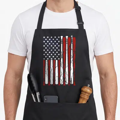 Flag baseball 4th of july apron - Distressed USA flag design formed by vertical red and white baseball bats with white — shown on a black cotton canvas apron against a white background