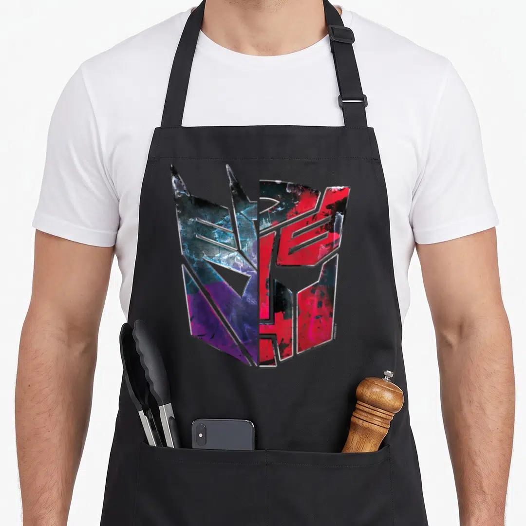 War split apron - Split Transformers logo graphic in red blue purple and black on black fabric — shown on a black cotton canvas apron against a white background