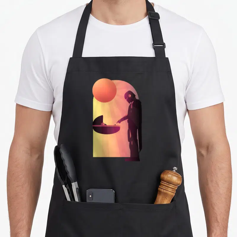 Epic novelty apron - Minimalist silhouette of helmeted figure and baby in cradle under a sun with rays in purple orange — shown on a black cotton canvas apron against a white background