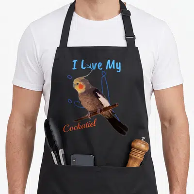 Talon bird apron - Photo of a cockatiel perched on a branch with blue and red text surrounded by blue circles — shown on a black cotton canvas apron against a white background