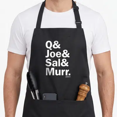 Joe fools apron - White stacked text Q Joe Sal Murr with small Impractical Jokers logo — shown on a black cotton canvas apron against a white background