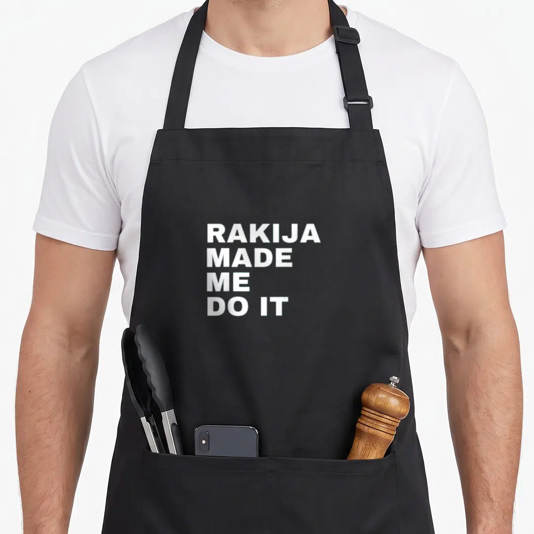 Rakija croatian aprons - White stacked text RAKIJA MADE ME DO IT on gray background — shown on a black cotton canvas apron against a white background