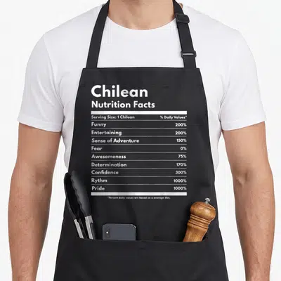 Chilean nutrition pride apron - White nutrition facts label text listing 1000% pride and 0% fear on a dark background — shown on a black cotton canvas apron against a white background