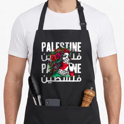 Bandana palestine palestinian apron - Woman with floral hair and keffiyeh surrounded by white Palestine text in English — shown on a black cotton canvas apron against a white background