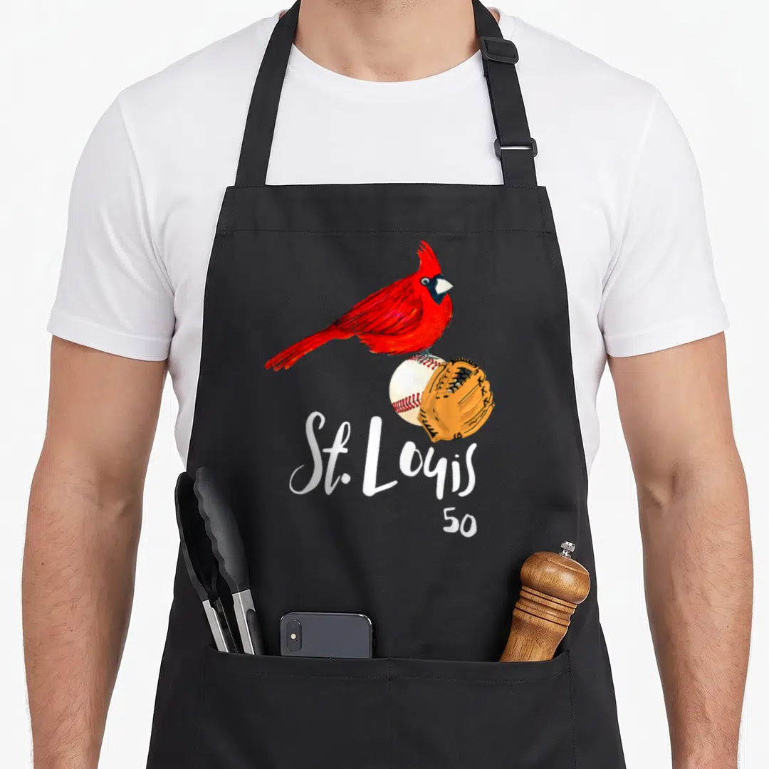 Louis cardinal apron - Red cardinal perched on baseball and glove with St. Louis 50 text below — shown on a black cotton canvas apron against a white background