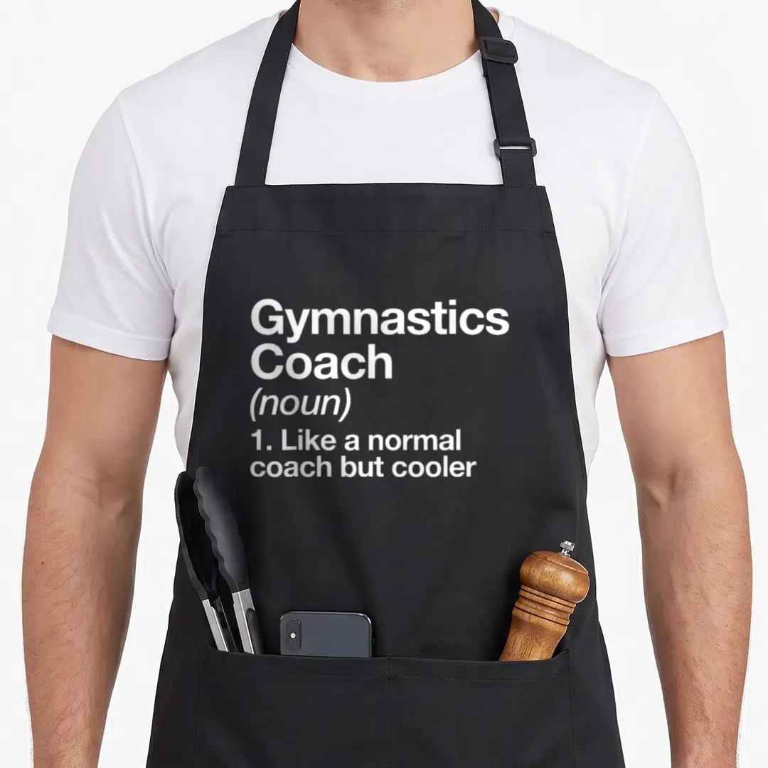 Gymnastic fitness coach apron - White stacked text reading Gymnastics Coach noun like a normal coach but cooler — shown on a black cotton canvas apron against a white background