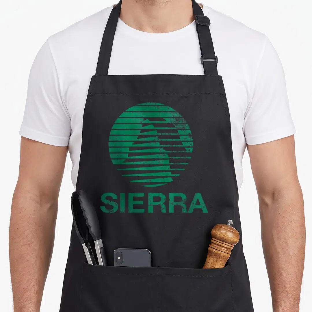 Faded sierra apron - Green circular logo with horizontal stripes and SIERRA text in distressed font — shown on a black cotton canvas apron against a white background