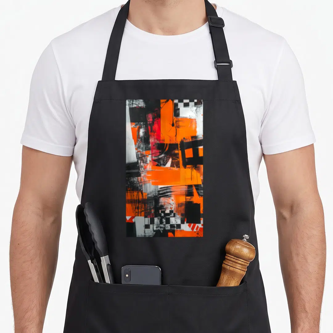 Graffiti modern apron - Vertical abstract art print with orange black white geometric shapes and checkerboard patterns — shown on a black cotton canvas apron against a white background
