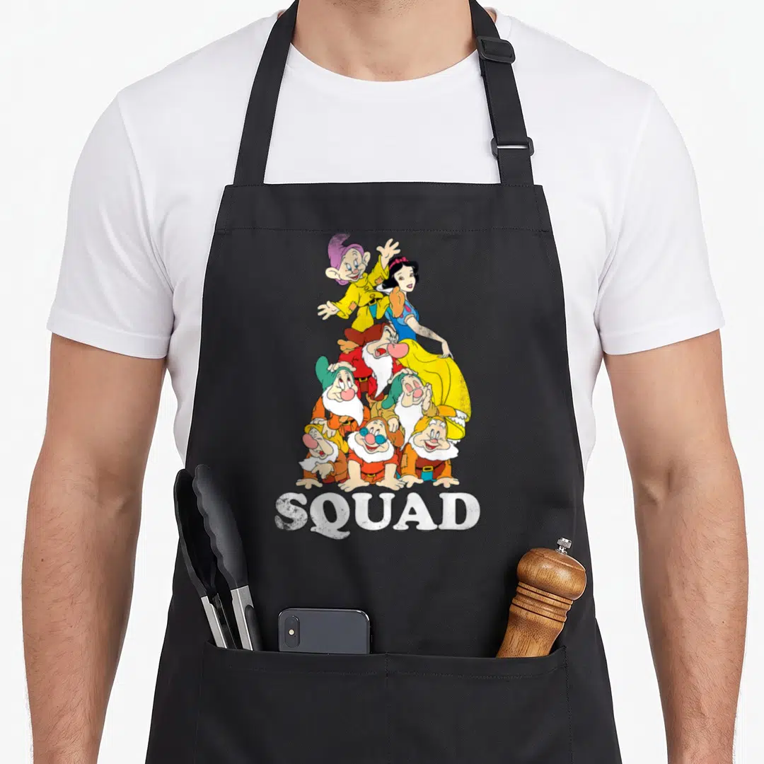 Dwarve snow white apron - Snow White and seven dwarfs stacked above white SQUAD text in cartoon style — shown on a black cotton canvas apron against a white background