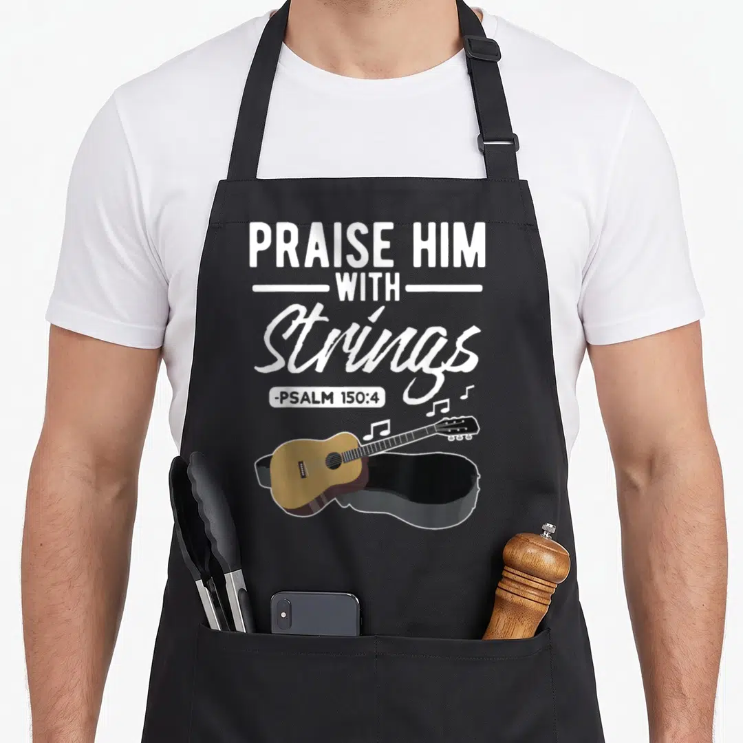 Praise congratulations apron - White PRAISE HIM WITH Strings text above brown acoustic guitar on black case with music — shown on a black cotton canvas apron against a white background
