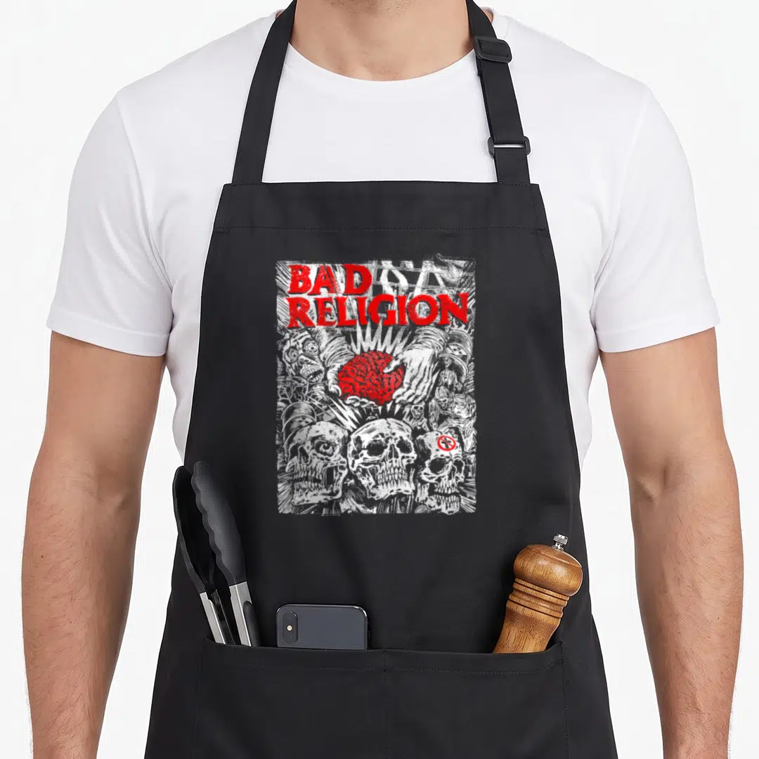 Religion brain apron - Distressed BAD RELIGION text, hands holding red brain, three skulls at bottom — shown on a black cotton canvas apron against a white background
