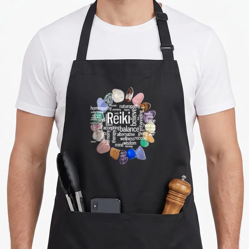 Reiki stone apron - Crystal cluster circle surrounding white Reiki and balance text in blue, purple, and pink — shown on a black cotton canvas apron against a white background