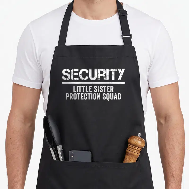 Protection birthday apron - White distressed text reading Security Little Sister Protection Squad separated — shown on a black cotton canvas apron against a white background