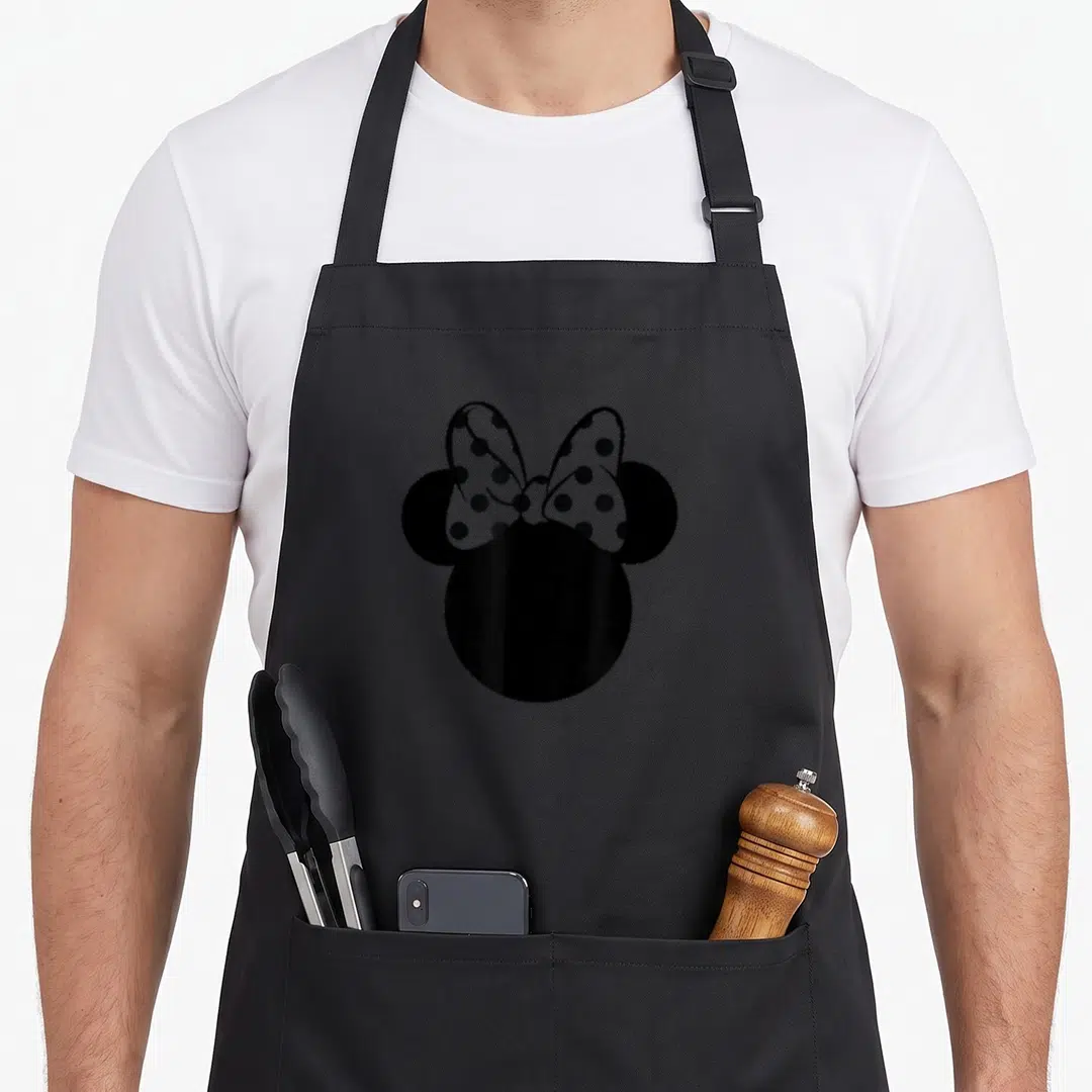 Ear bow apron - Black mouse head silhouette with white polka dot bow on top — shown on a black cotton canvas apron against a white background