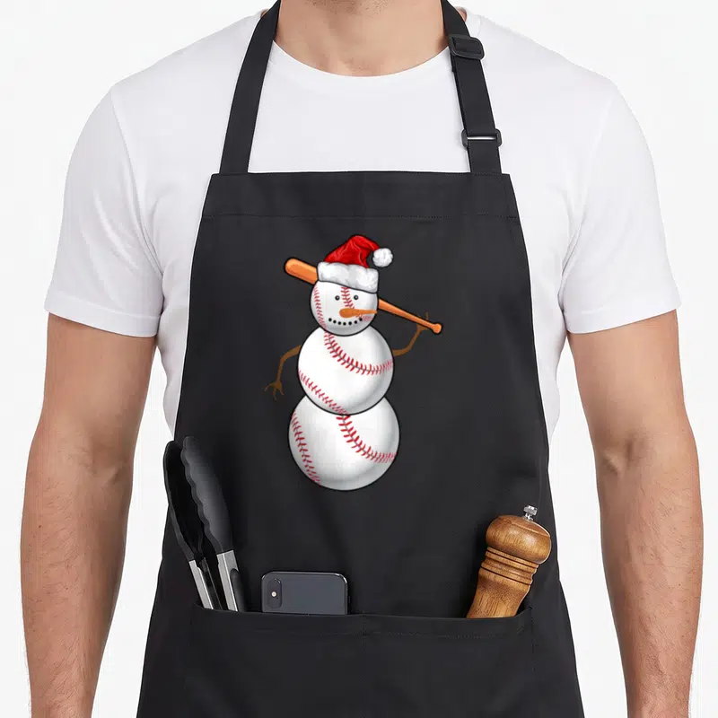 Baseball christmas snowman apron - Cartoon snowman made of white baseballs wearing red Santa hat holding tan bat — shown on a black cotton canvas apron against a white background