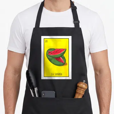 Sandia watermelon apron - Yellow card with 28, two watermelon slices, and LA SANDÍA text — shown on a black cotton canvas apron against a white background
