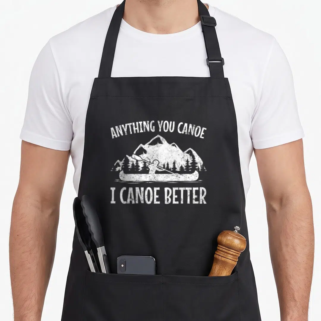 Anything canoe apron - White distressed text and paddler silhouette against mountains — shown on a black cotton canvas apron against a white background