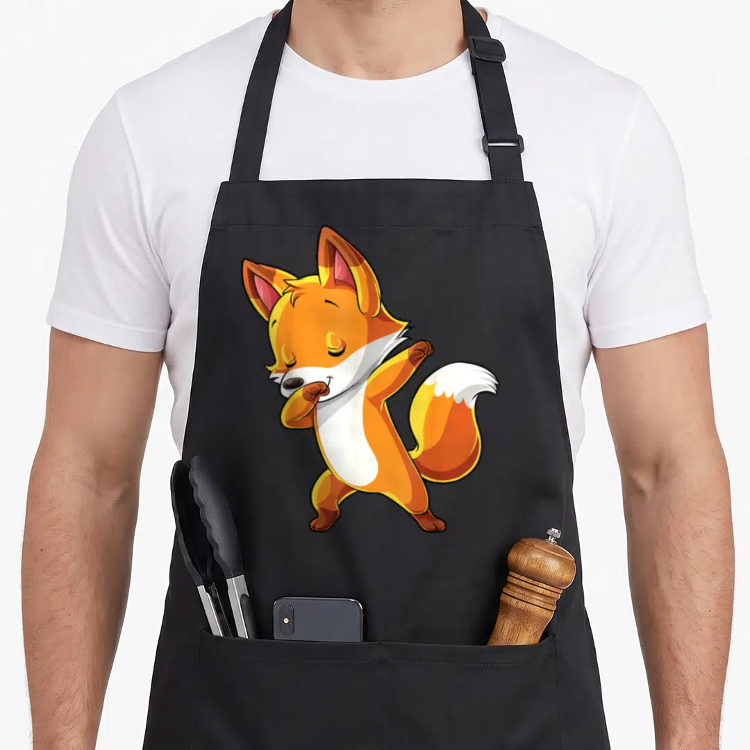 Dabbing fox aprons - Orange and white cartoon fox performing a dab dance pose — shown on a black cotton canvas apron against a white background