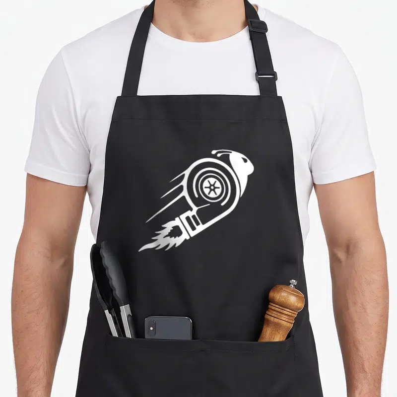 Turbo racing apron - White snail silhouette shaped like a rocket with speed lines and fire trails on black background — shown on a black cotton canvas apron against a white background