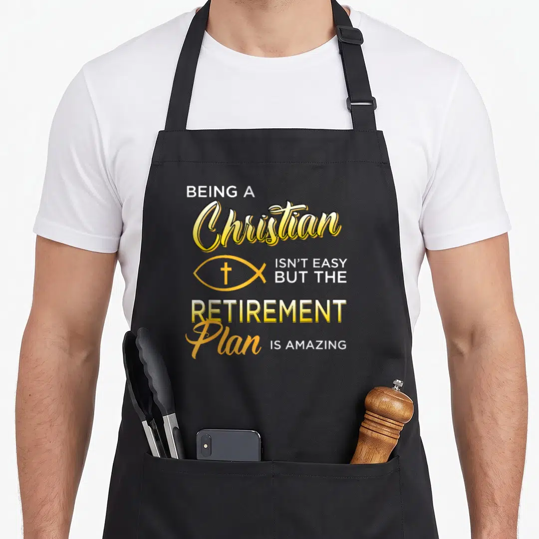 Gospel christian apron - Stacked yellow and white text reading BEING A Christian ISN'T EASY BUT THE RETIREMENT Plan IS — shown on a black cotton canvas apron against a white background