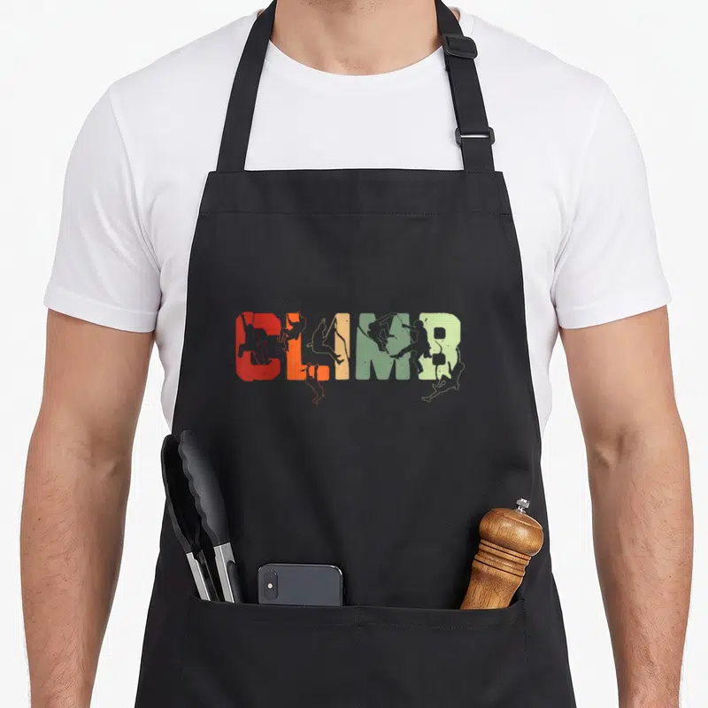 Enthusiast bouldering addict apron - CLIMB text with integrated climber silhouettes in red, orange, beige, green, grey — shown on a black cotton canvas apron against a white background