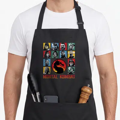 Klassic character aprons - MORTAL KOMBAT text below grid of realistic character headshots around a red and black dragon — shown on a black cotton canvas apron against a white background