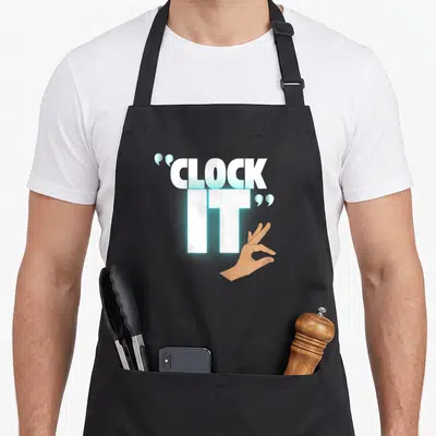 Clock viral apron - Stacked CLOCK IT text with brown hand making an OK sign in white and blue — shown on a black cotton canvas apron against a white background