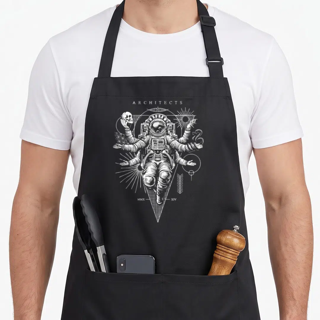 Astronaut architect apron - White line art of multi-armed astronaut holding skull and snake surrounded by geometric — shown on a black cotton canvas apron against a white background
