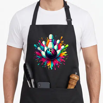 Bowling colorful aprons - Cartoon bowling ball and five pins surrounded by pink blue yellow green and black paint — shown on a black cotton canvas apron against a white background