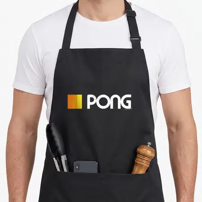 Pong gamer retro apron - White PONG text beside three vertical orange and yellow bars — shown on a black cotton canvas apron against a white background
