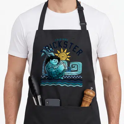 Original novelty apron - Maui Original Trickster cartoon with blue sun palm tree and wave — shown on a black cotton canvas apron against a white background