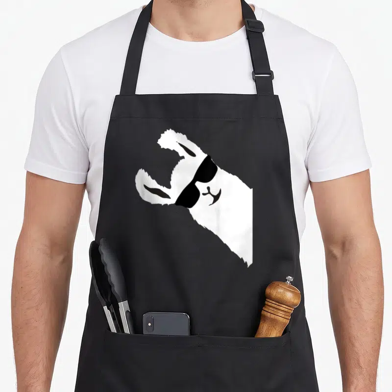 Sunglass alpaca apron - White llama silhouette wearing black sunglasses on black bib apron — shown on a black cotton canvas apron against a white background