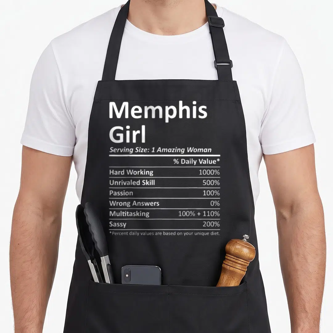 Proud memphis apron - White nutrition facts label reading Memphis Girl with Hard Working 1000 percent and Sassy 200 — shown on a black cotton canvas apron against a white background