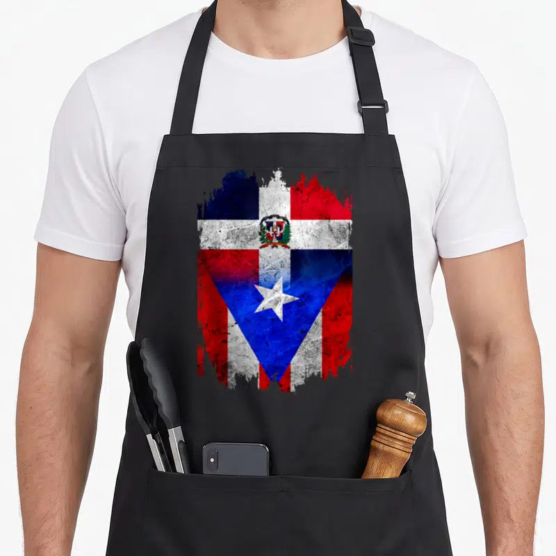Puerto dominican apron - Distressed red white blue flag merging Dominican coat of arms and Puerto Rican star — shown on a black cotton canvas apron against a white background