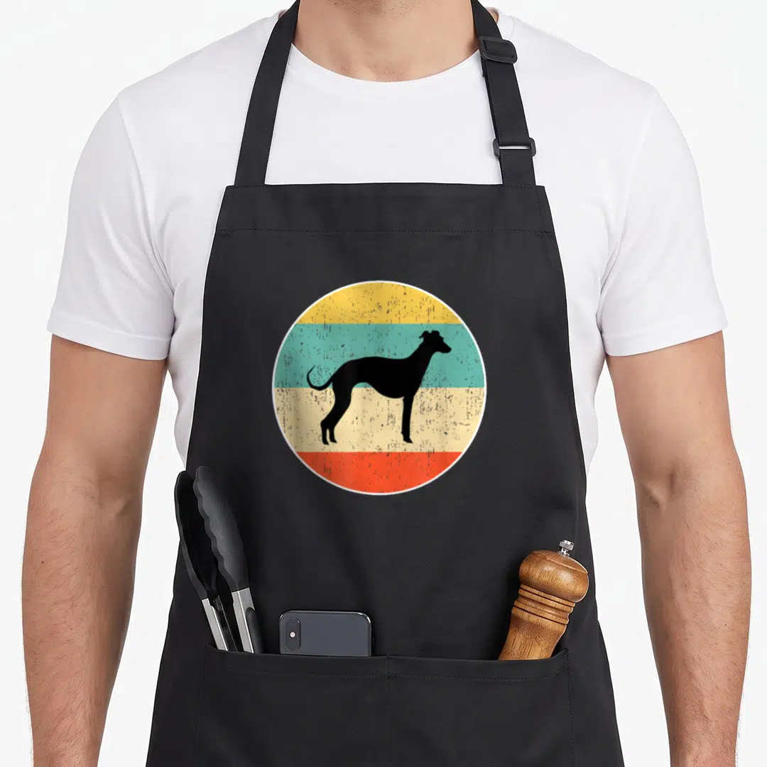 Retro whippet dog apron - Black whippet silhouette on four colored stripes: yellow, teal, beige, red circle — shown on a black cotton canvas apron against a white background