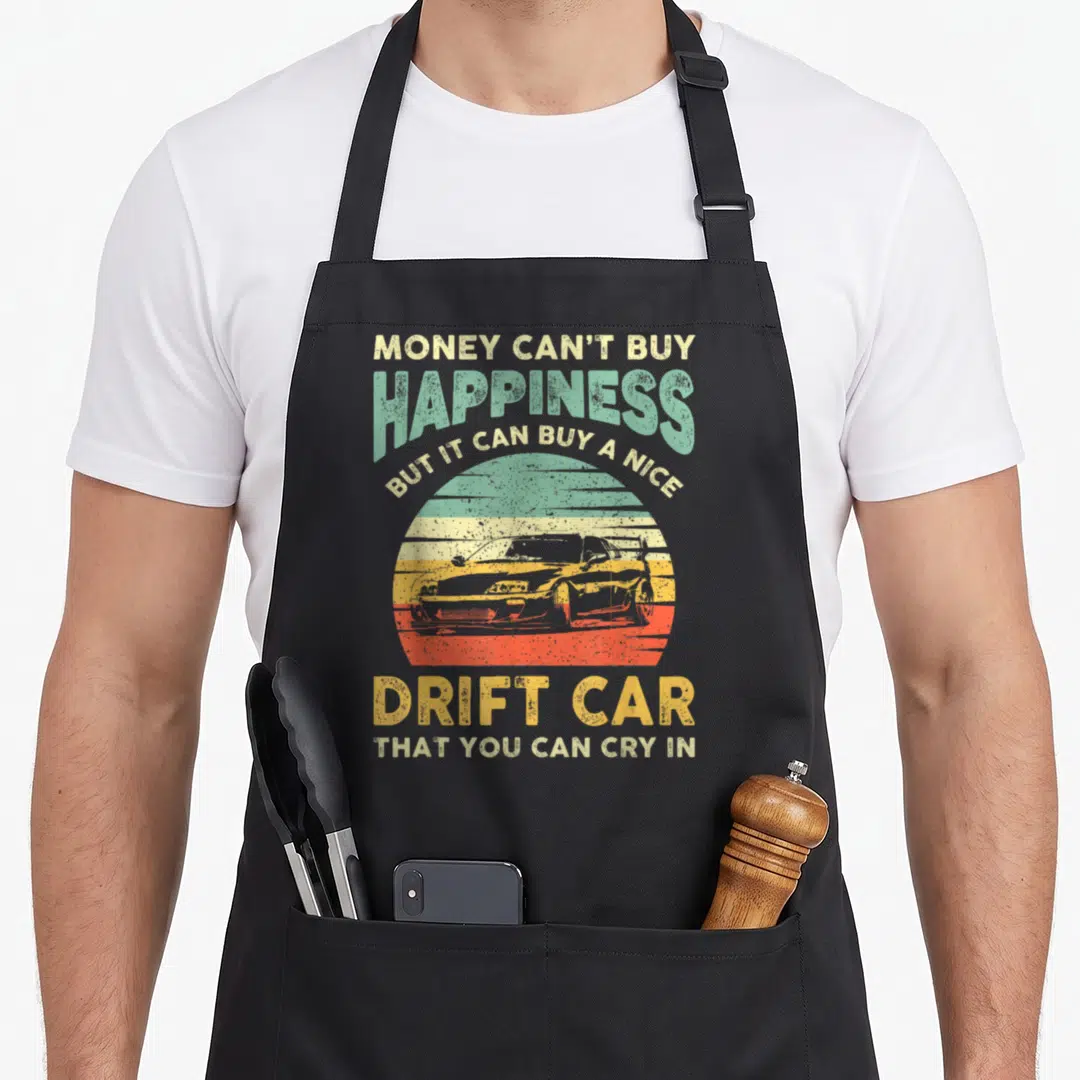 Joke car apron - Retro sunset graphic with drift car silhouette and text about buying a drift car — shown on a black cotton canvas apron against a white background