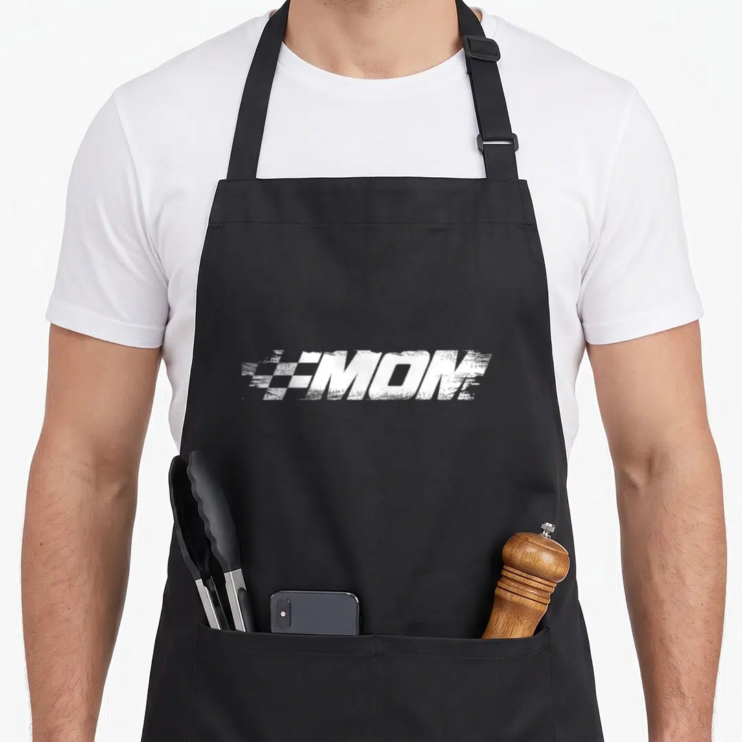 Mum car apron - White distressed MOM text with checkered racing flag pattern on left side of letter M — shown on a black cotton canvas apron against a white background