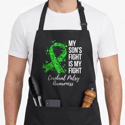 Son cerebral palsy awareness apron - Green heart ribbon and white text MY SON'S FIGHT IS MY FIGHT Cerebral Palsy — shown on a black cotton canvas apron against a white background