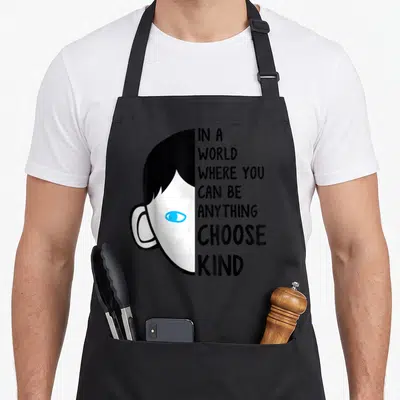 Anything choose kindness be kind inspirational apron - Stacked text reading IN A WORLD WHERE YOU CAN BE ANYTHING CHOOSE — shown on a black cotton canvas apron against a white background