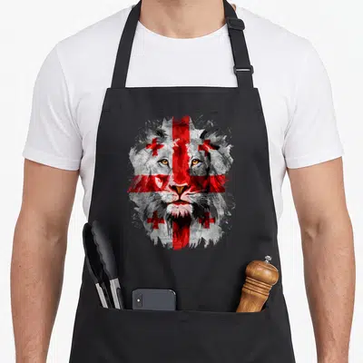 Georgia face apron - Distressed lion head with red white flag overlay painterly style — shown on a black cotton canvas apron against a white background
