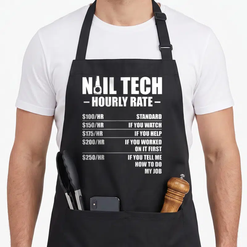 Rate manicurist apron - White nail tech hourly rate typography with nail polish bottle in letter — shown on a black cotton canvas apron against a white background