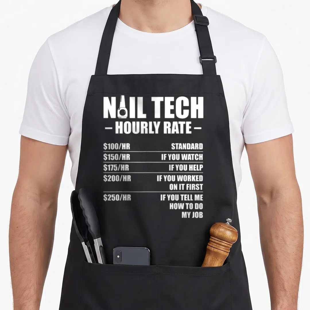 Rate manicurist apron - White nail tech hourly rate typography with nail polish bottle in letter — shown on a black cotton canvas apron against a white background